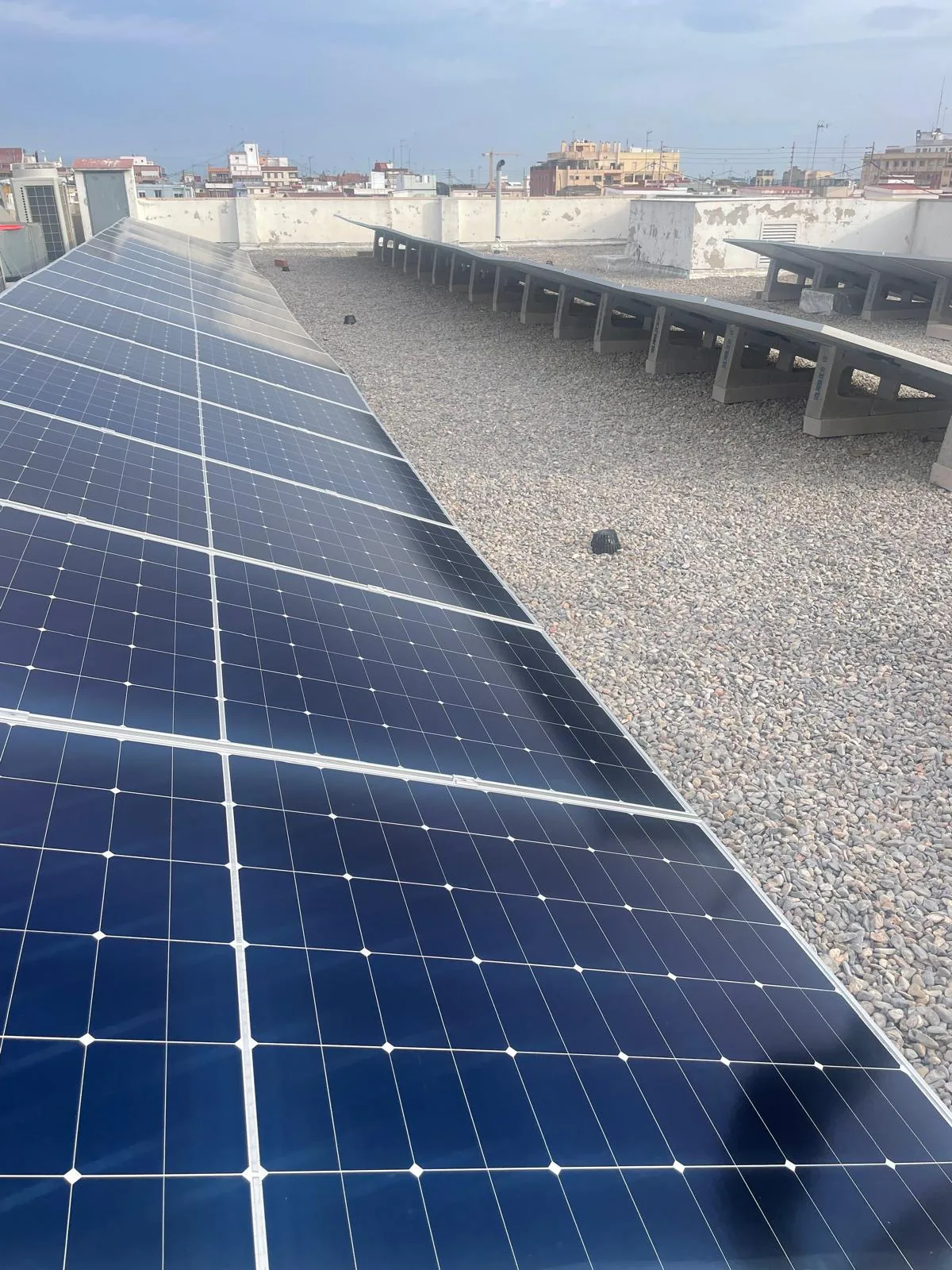 Detalle de una instalación fotovoltaica sobre cubierta plana de grava
